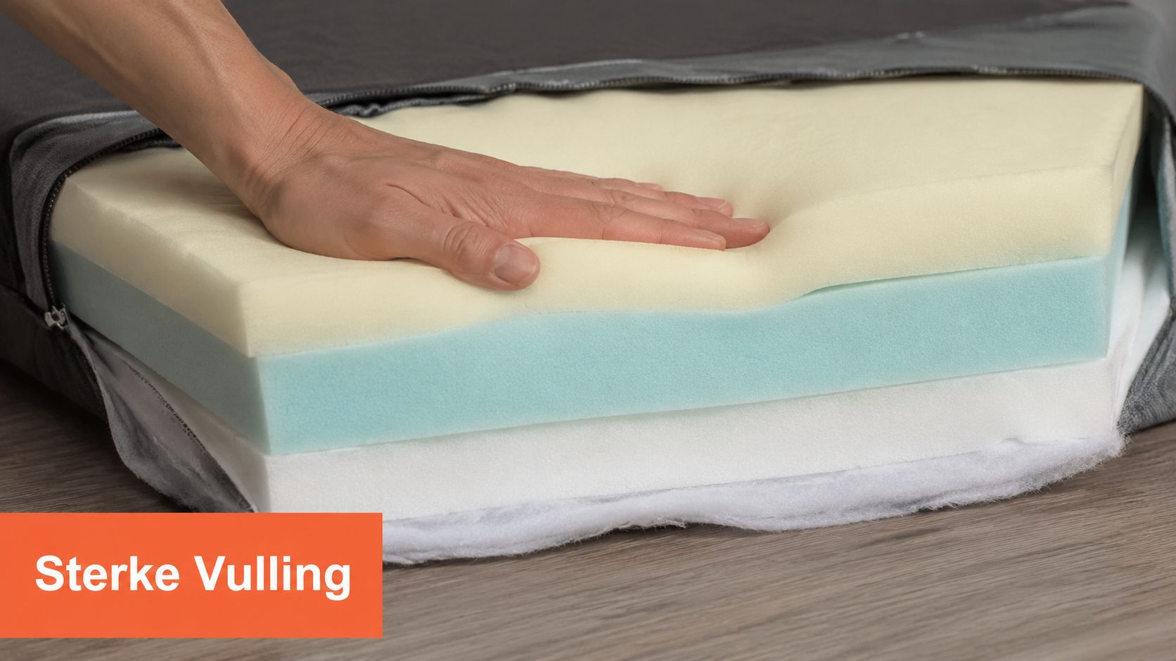 Een hand drukt op de meerlaagse schuimvulling van een comfortabel hondenbed voor grote honden.